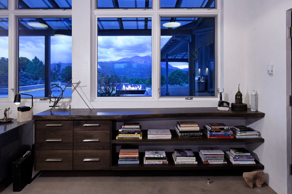 Inspiration for a mid-sized modern home studio in Denver with concrete floors and a freestanding desk.