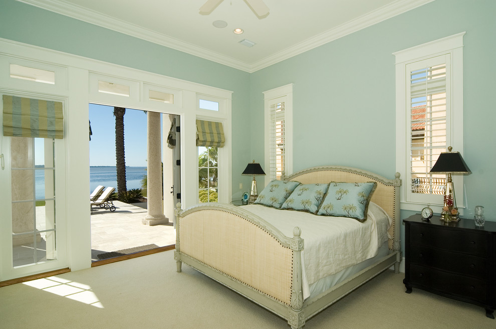 This is an example of a mid-sized beach style guest bedroom in Miami with blue walls, carpet and no fireplace.