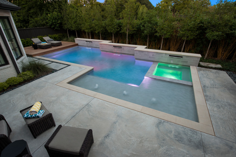 Photo of a mid-sized modern backyard custom-shaped lap pool in Dallas with a hot tub and concrete slab.