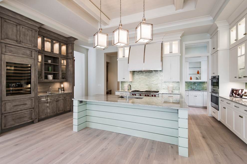 Example of a transitional light wood floor open concept kitchen design with stainless steel appliances and an island