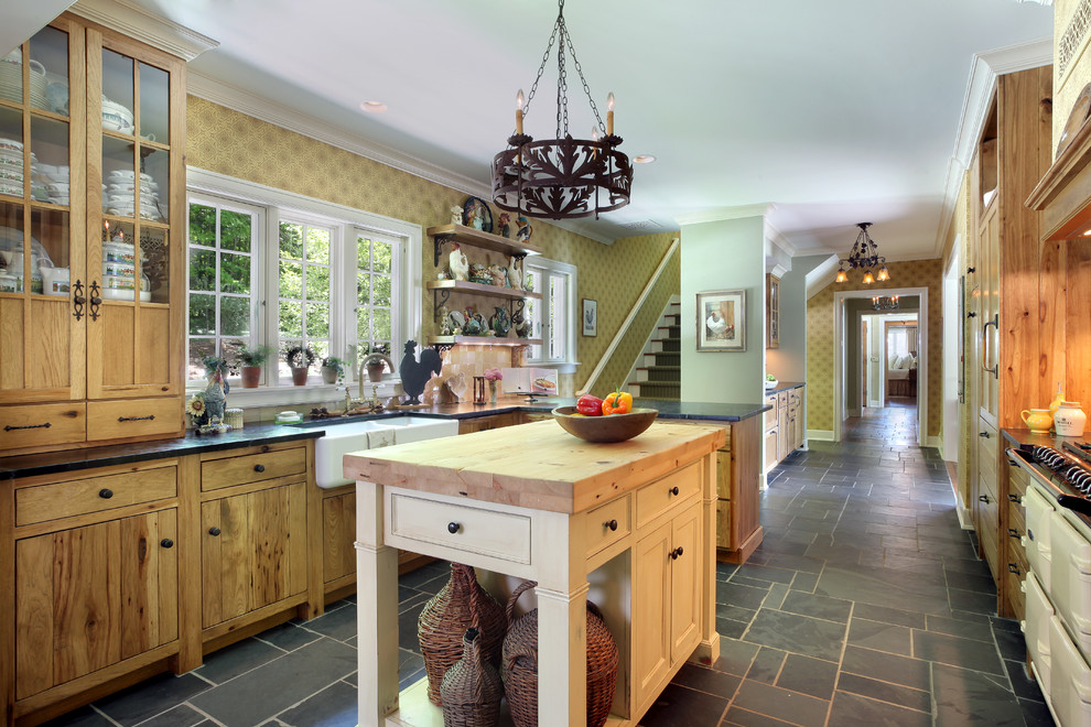 This is an example of a country galley kitchen in Grand Rapids with a farmhouse sink, flat-panel cabinets, medium wood cabinets, coloured appliances and with island.