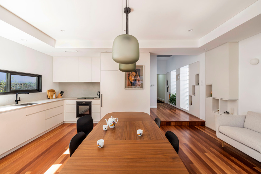 Exemple d'une salle à manger ouverte sur le salon tendance de taille moyenne avec un sol en bois brun, aucune cheminée et un sol marron.