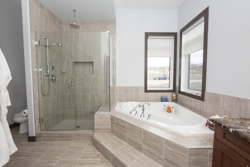 Photo of a large contemporary master bathroom in Edmonton with recessed-panel cabinets, medium wood cabinets, laminate benchtops, a corner tub, an alcove shower, a one-piece toilet, beige tile, ceramic tile, white walls and ceramic floors.