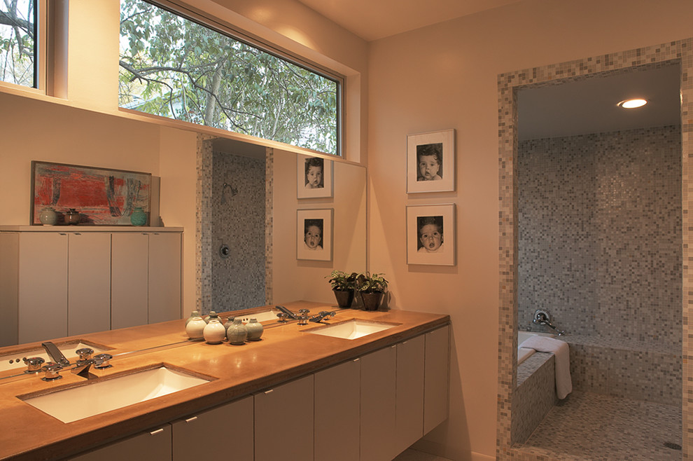 Mid-sized midcentury master bathroom in Austin with flat-panel cabinets, white cabinets, a drop-in tub, a corner shower, mirror tile, beige walls, mosaic tile floors, an undermount sink and wood benchtops.