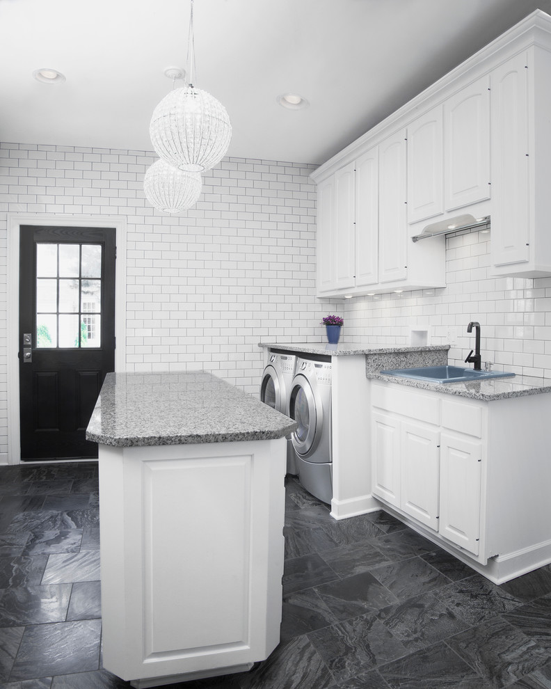 Large transitional single-wall utility room in Chicago with a drop-in sink, raised-panel cabinets, white cabinets, granite benchtops, white walls, ceramic floors, a side-by-side washer and dryer and grey floor.