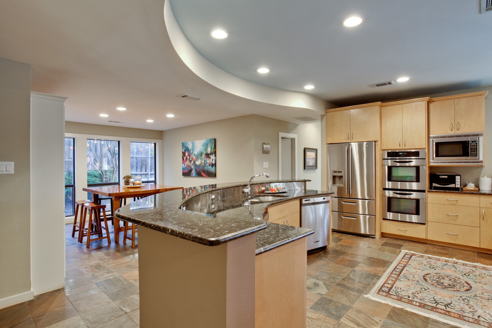 Large traditional l-shaped kitchen pantry in Dallas with an undermount sink, flat-panel cabinets, light wood cabinets, granite benchtops, beige splashback, stainless steel appliances, travertine floors, with island and multi-coloured floor.