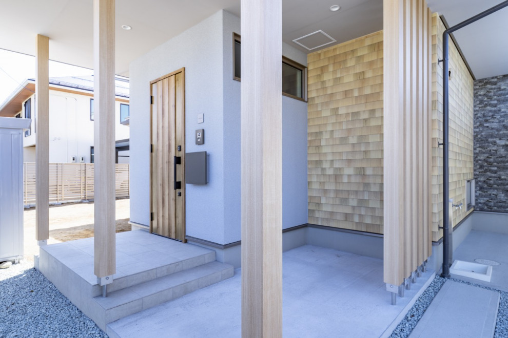 Foto på en mellanstor funkis hall, med vita väggar, ljust trägolv, en enkeldörr, ljus trädörr och brunt golv