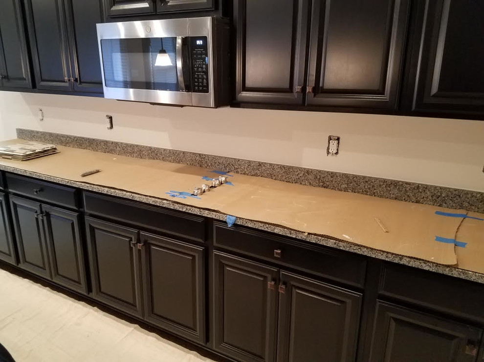 Transitional dark wood floor and brown floor eat-in kitchen photo in DC Metro with a drop-in sink, dark wood cabinets, granite countertops, multicolored backsplash, glass tile backsplash, stainless steel appliances and multicolored countertops