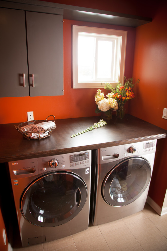 Photo of a transitional laundry room in Los Angeles with brown cabinets, beige floor and brown benchtop.