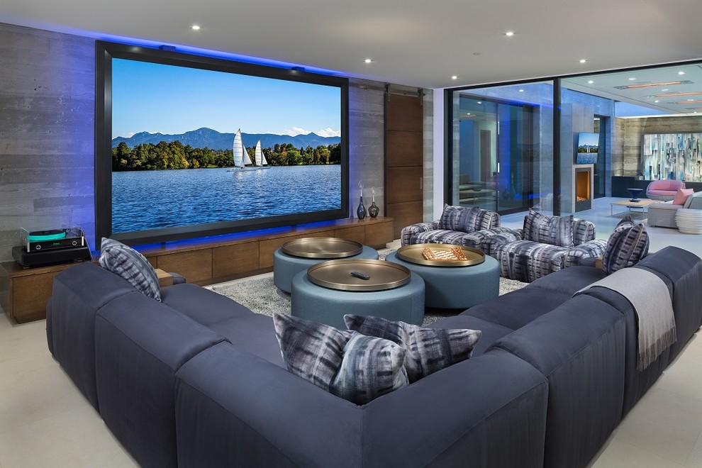 Contemporary open concept home theatre in Los Angeles with grey walls, a projector screen and grey floor.