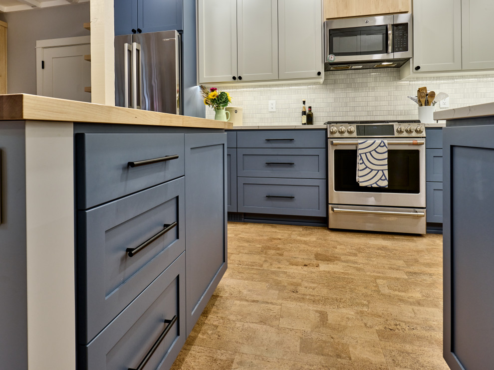 Cork floor, beige floor and exposed beam eat-in kitchen photo with a single-bowl sink, shaker cabinets, blue cabinets, quartz countertops, gray backsplash, ceramic backsplash, stainless steel appliances, an island and white countertops