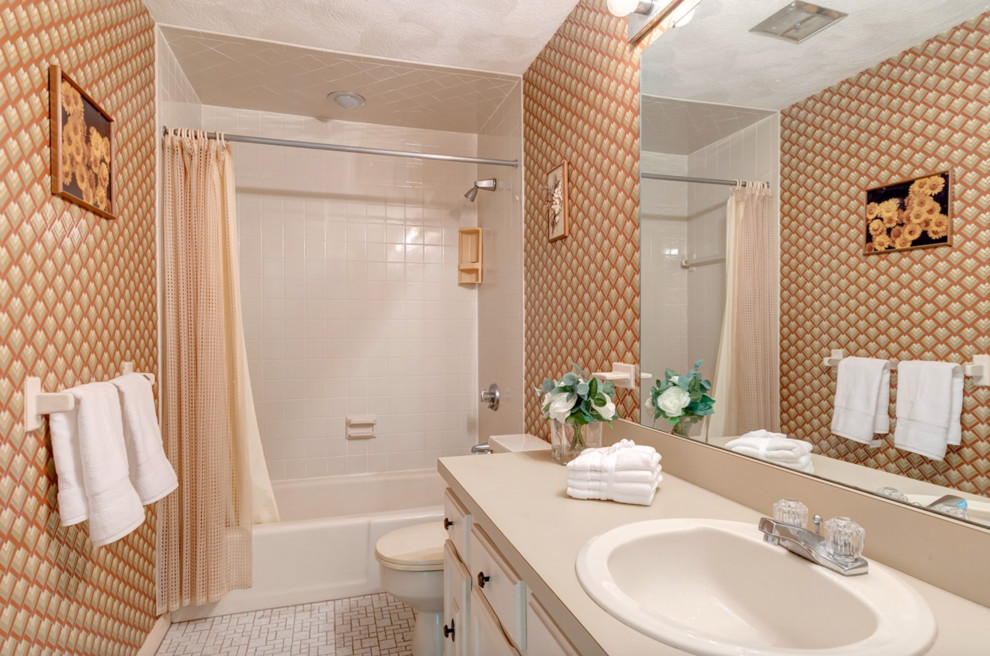 This is an example of a mid-sized contemporary master bathroom in Boston with raised-panel cabinets, white cabinets, multi-coloured tile, solid surface benchtops and beige benchtops.
