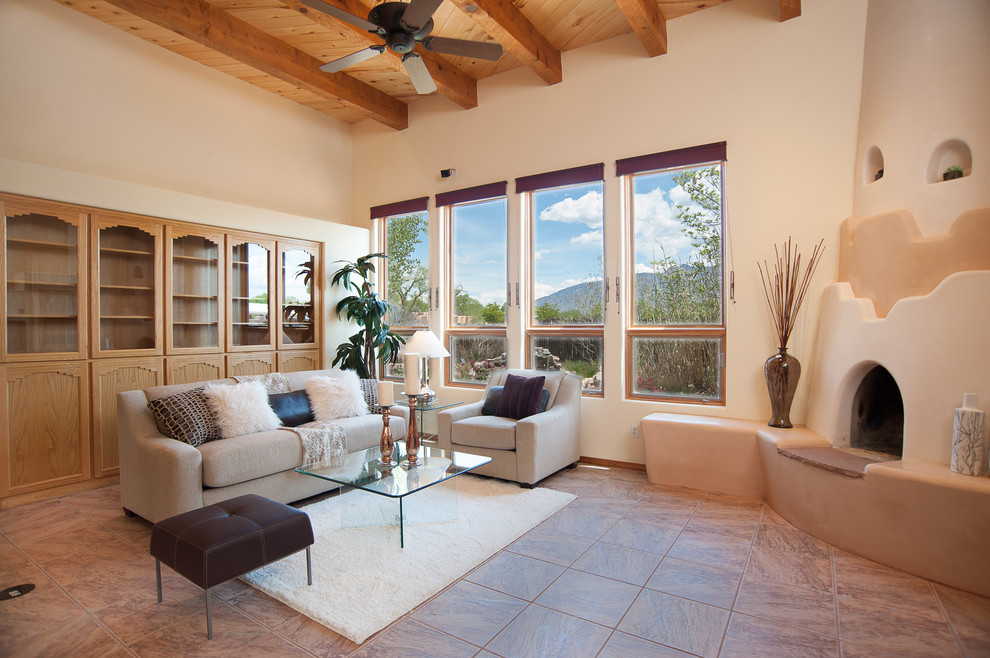 This is an example of a large formal open concept living room in Albuquerque with white walls, porcelain floors, a standard fireplace, a plaster fireplace surround and a built-in media wall.