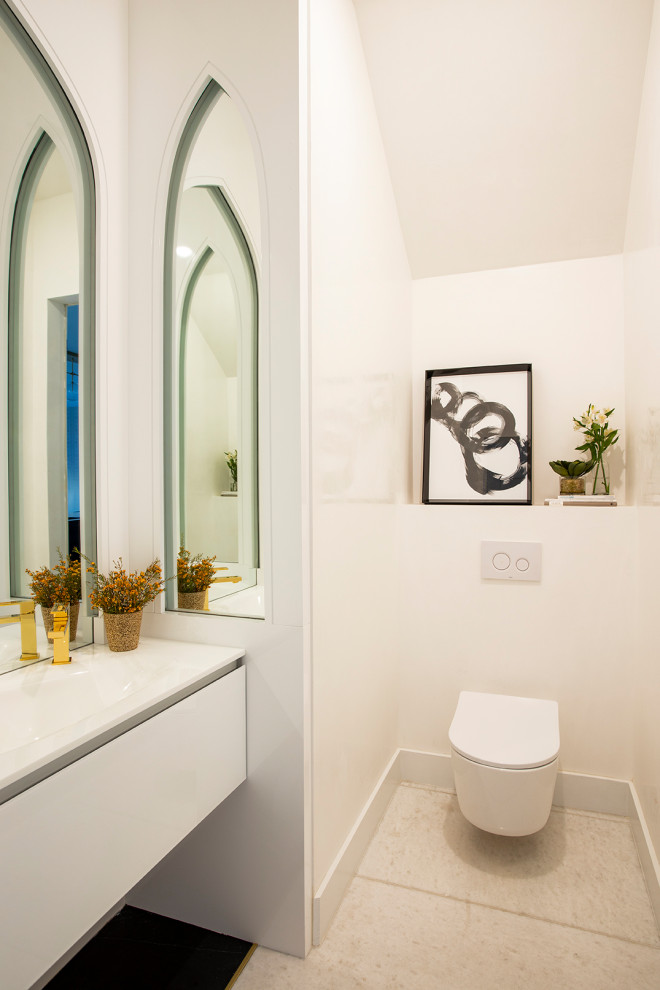 Inspiration for a large contemporary powder room in Miami with flat-panel cabinets, white cabinets, white tile, white walls, marble floors, glass benchtops, white floor, white benchtops, a wall-mount toilet, an integrated sink and vaulted.