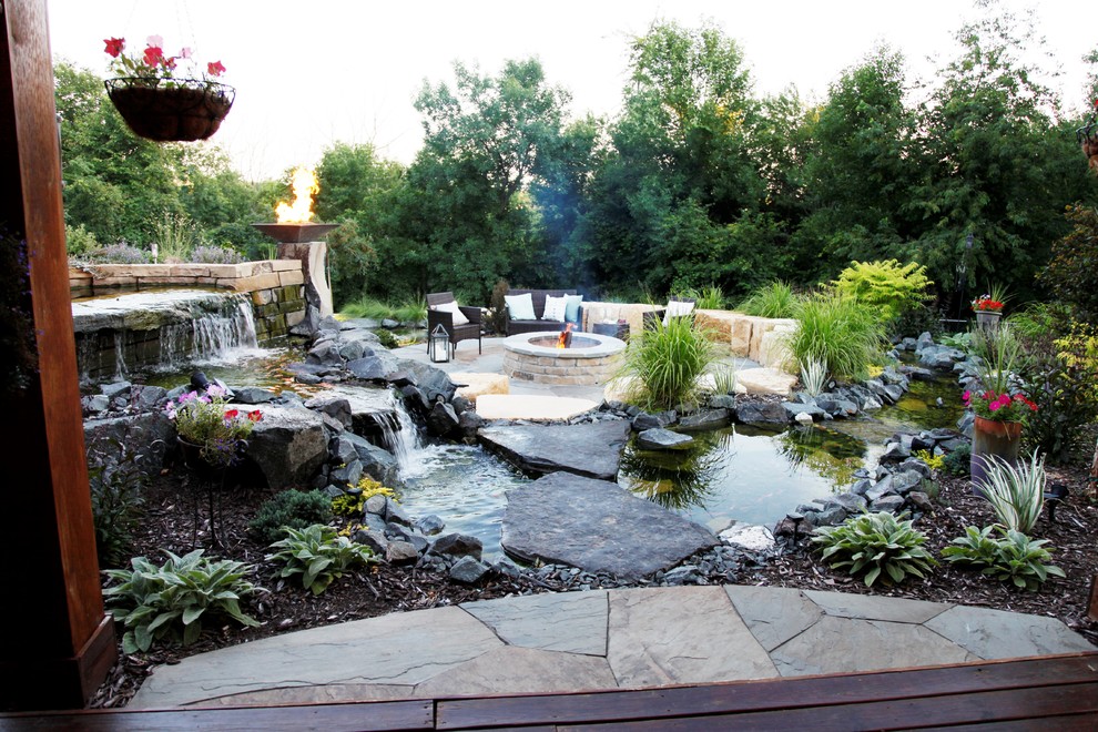 Design ideas for a large transitional backyard partial sun formal garden for summer in Minneapolis with a fire feature and natural stone pavers.