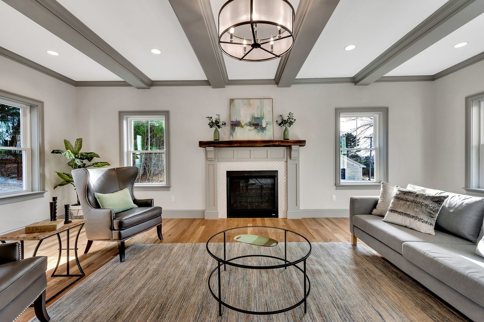 Inspiration for a transitional formal enclosed living room in Boston with grey walls, medium hardwood floors, a standard fireplace and brown floor.