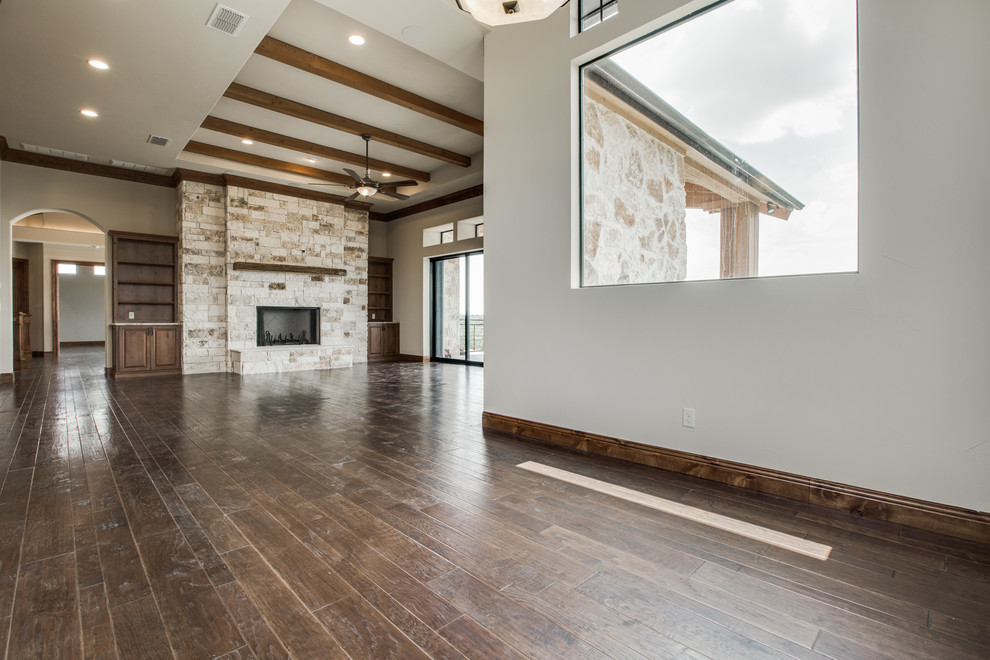Inspiration for a large transitional kitchen/dining combo in Austin with beige walls, dark hardwood floors, a standard fireplace and a stone fireplace surround.
