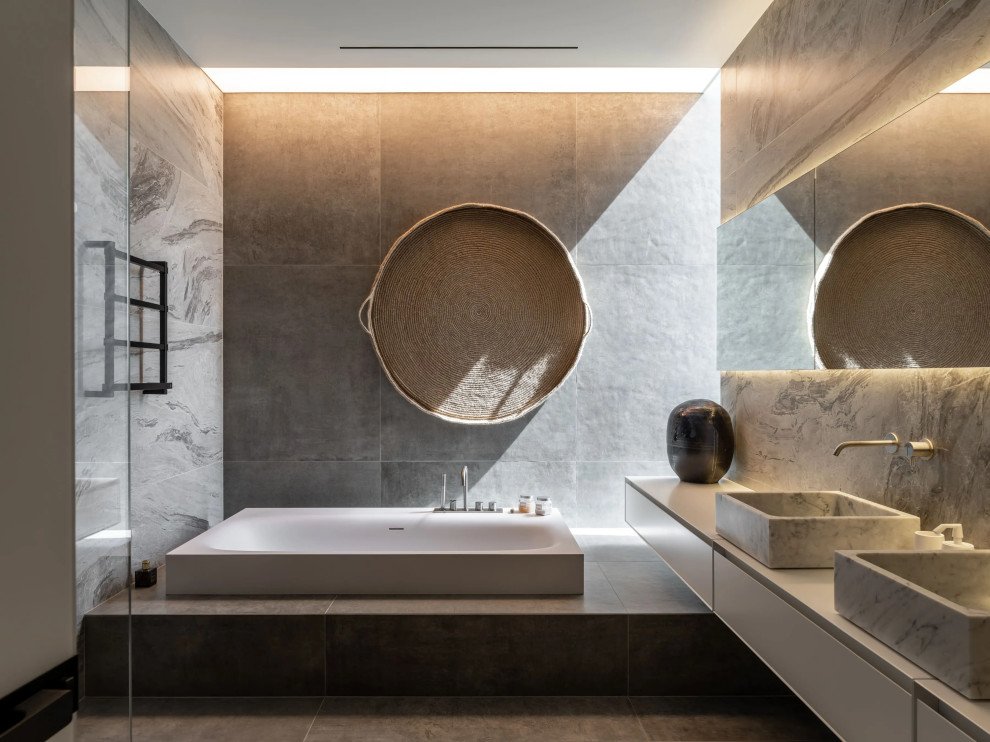 Стильный дизайн: главная ванная комната среднего размера в стиле модернизм с открытыми фасадами, серыми фасадами, угловой ванной, угловым душем, унитазом-моноблоком, серой плиткой, мраморной плиткой, серыми стенами, мраморным полом, монолитной раковиной, мраморной столешницей, серым полом, открытым душем, серой столешницей, тумбой под две раковины и встроенной тумбой - последний тренд