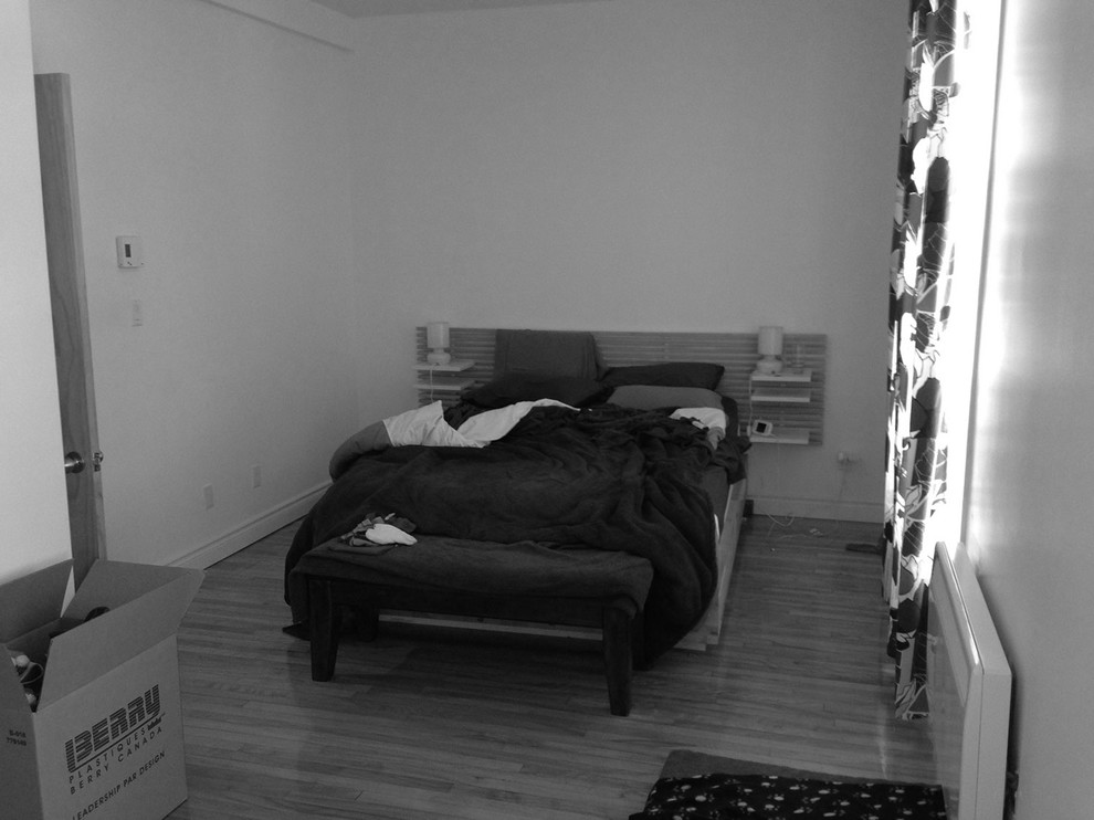 Cette image montre une petite chambre traditionnelle avec un mur blanc et un sol en bois brun.