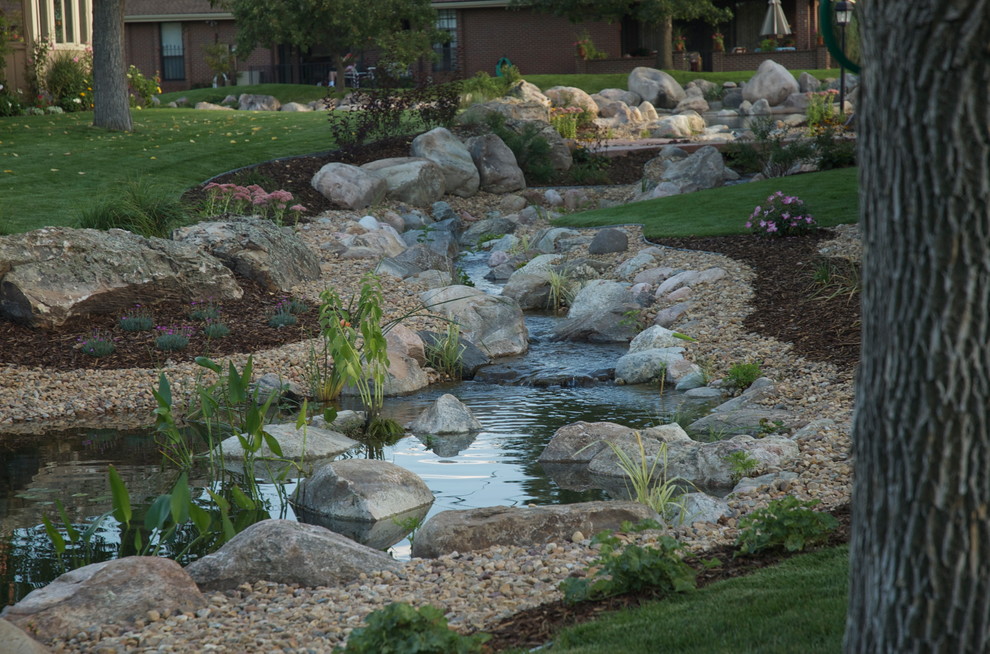 Photo of an expansive traditional garden in Denver with a water feature.