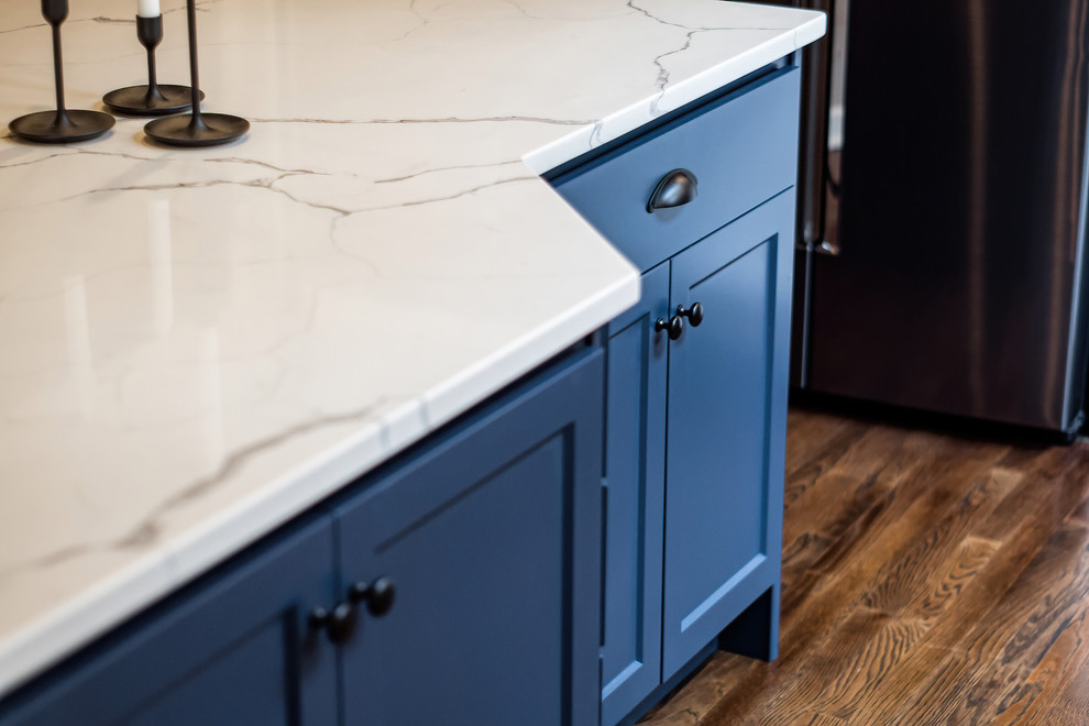 Inspiration for a large transitional u-shaped eat-in kitchen remodel in Columbus with shaker cabinets, quartz countertops, white backsplash and an island