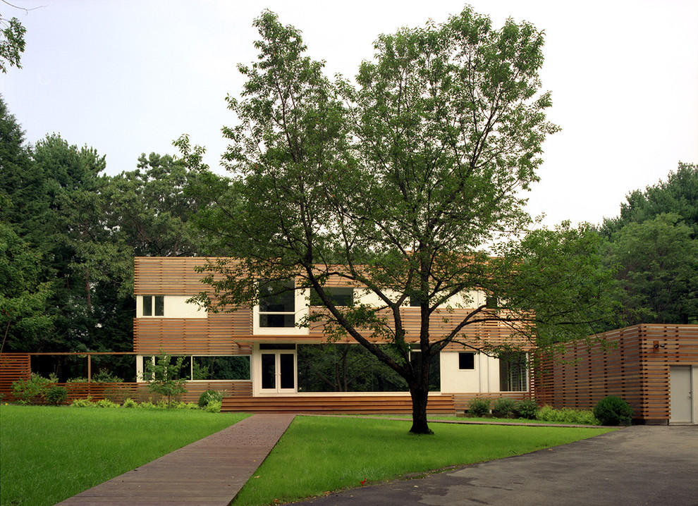 Photo of a large modern two-storey brown exterior in Boston with mixed siding and a flat roof.