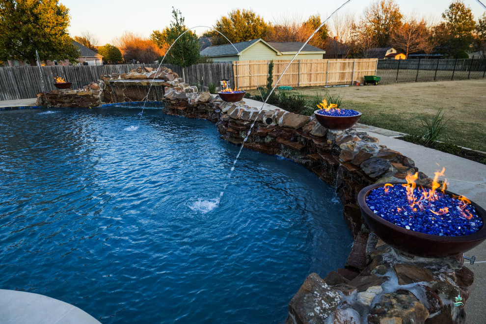 Pool landscaping - huge rustic backyard concrete paver and custom-shaped natural pool landscaping idea in Dallas