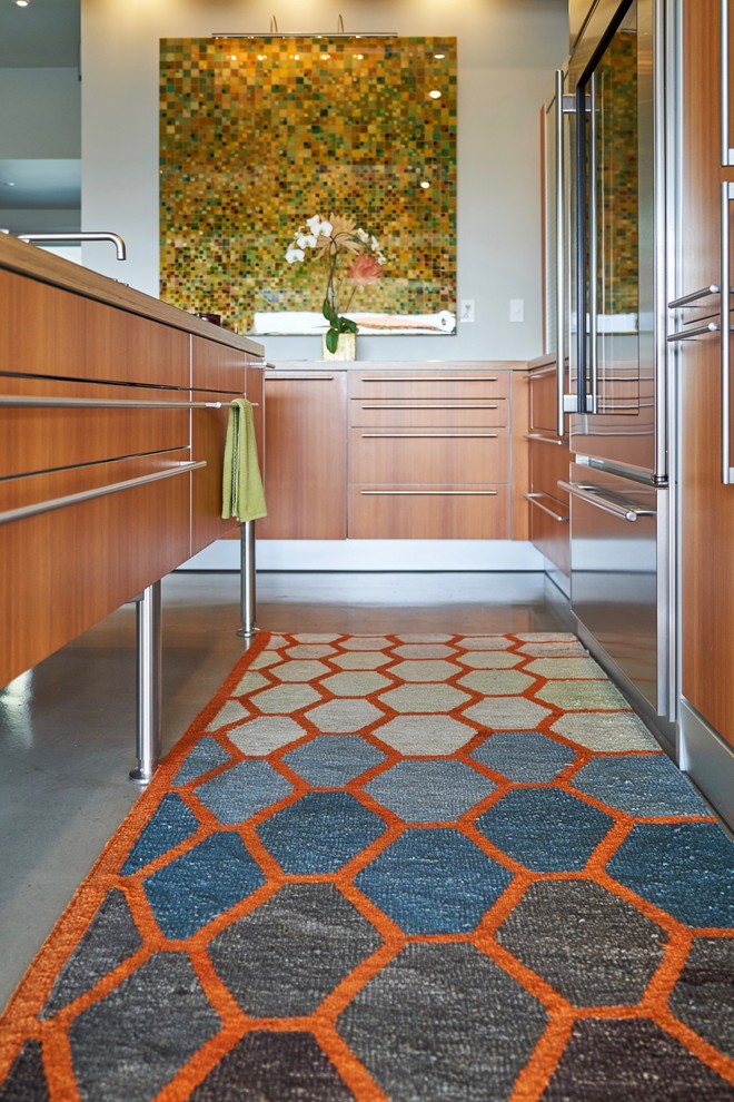 Inspiration for a small midcentury l-shaped eat-in kitchen in San Diego with a drop-in sink, flat-panel cabinets, medium wood cabinets, stainless steel benchtops, grey splashback, stainless steel appliances, concrete floors, with island, grey floor and grey benchtop.