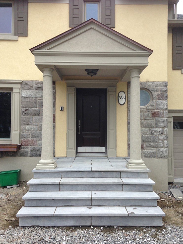 Design ideas for a large traditional two-storey beige exterior in Montreal with stone veneer.