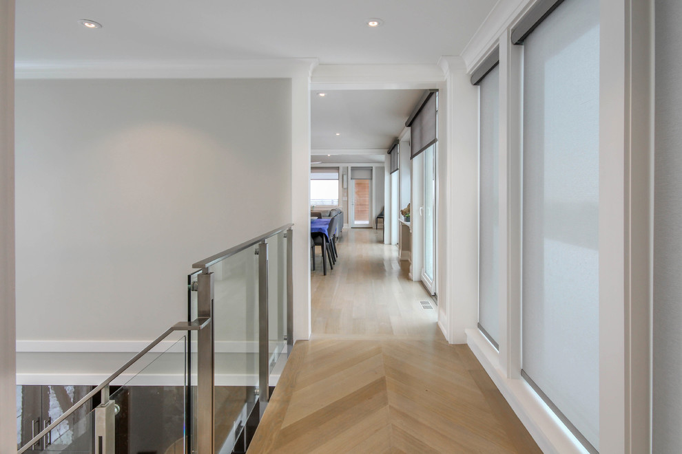 Photo of a modern hallway in Boston with white walls and light hardwood floors.