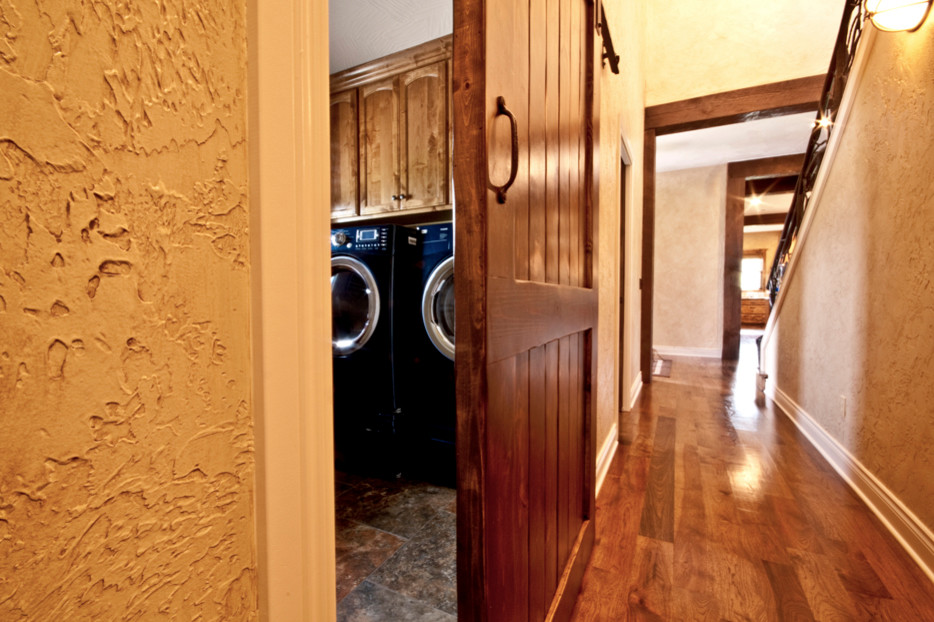 Dedicated laundry room in Other with raised-panel cabinets, medium wood cabinets, beige walls, terra-cotta floors and a side-by-side washer and dryer.