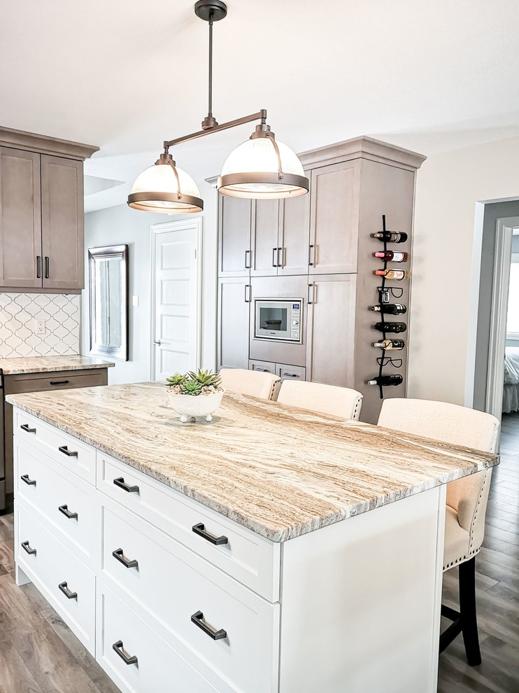 Mid-sized transitional l-shaped medium tone wood floor and brown floor open concept kitchen photo in Toronto with an undermount sink, shaker cabinets, light wood cabinets, granite countertops, white backsplash, porcelain backsplash, stainless steel appliances, an island and beige countertops