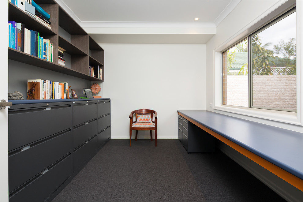 Photo of a mid-sized contemporary home office in Brisbane with white walls, carpet and a built-in desk.