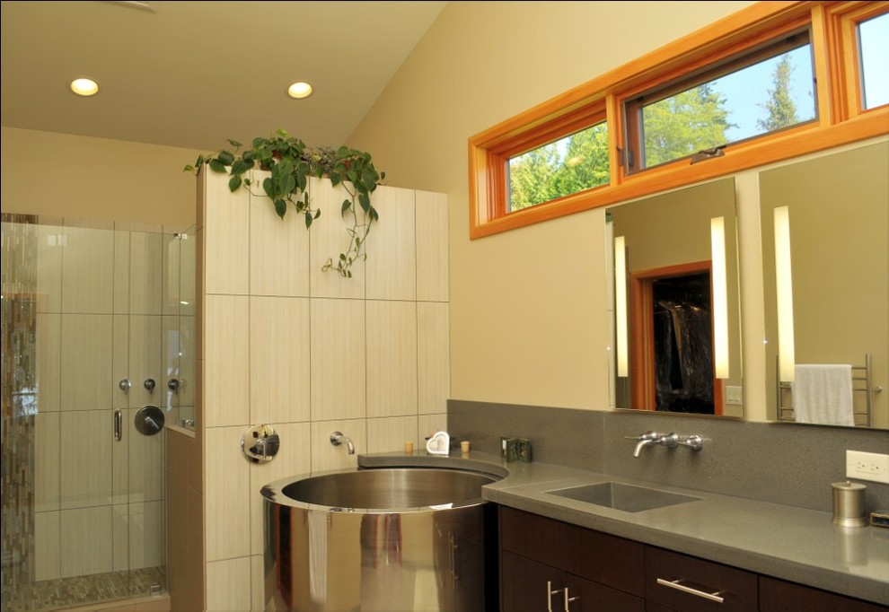 Inspiration for a large contemporary master bathroom in Seattle with an integrated sink, flat-panel cabinets, dark wood cabinets, solid surface benchtops, a japanese tub, an alcove shower, a two-piece toilet, beige tile, subway tile and beige walls.