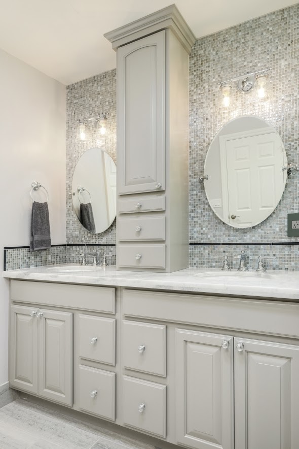 Inspiration for a large transitional master gray tile and mosaic tile laminate floor and beige floor corner shower remodel with raised-panel cabinets, gray cabinets, beige walls, an undermount sink, quartzite countertops, a hinged shower door and white countertops