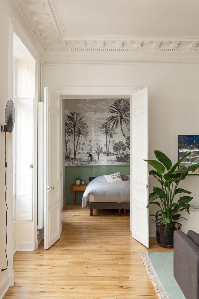 Diseño de dormitorio principal de tamaño medio sin chimenea con paredes blancas, suelo de madera clara, suelo beige y papel pintado