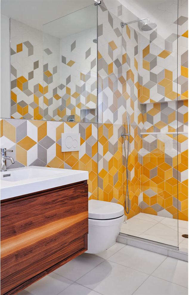 Photo of a contemporary 3/4 bathroom in New York with flat-panel cabinets, medium wood cabinets, a corner shower, a wall-mount toilet, gray tile, orange tile, white tile, a console sink and white floor.