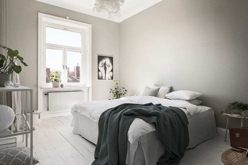 Photo of a mid-sized scandinavian master bedroom in Stockholm with grey walls, painted wood floors, no fireplace and white floor.