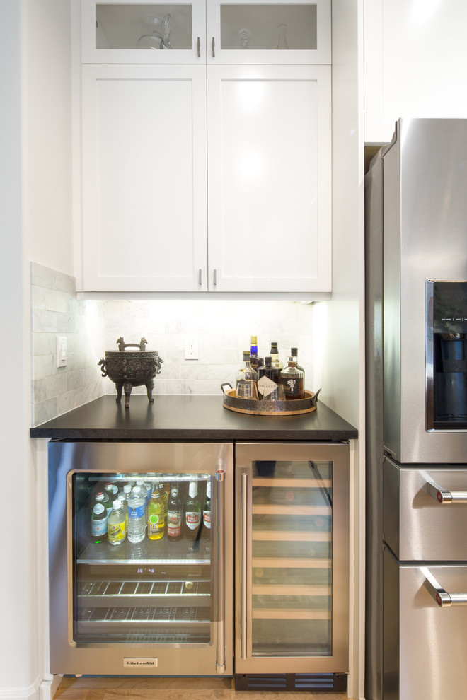 Inspiration for a mid-sized transitional l-shaped light wood floor and brown floor eat-in kitchen remodel in Seattle with an undermount sink, shaker cabinets, white cabinets, quartz countertops, multicolored backsplash, marble backsplash, stainless steel appliances and an island