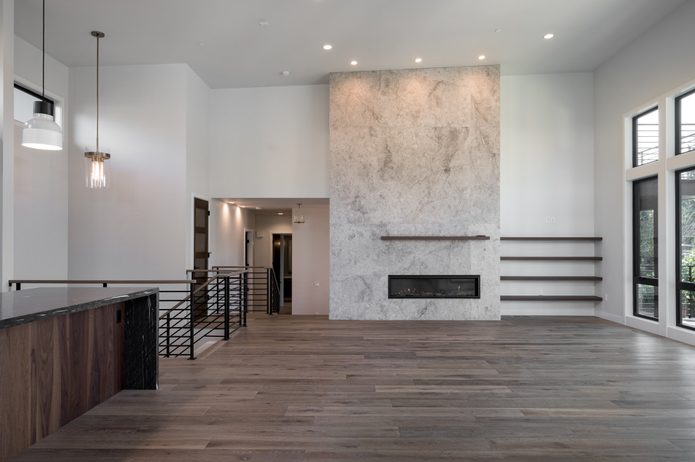 Geräumiges, Offenes Modernes Wohnzimmer mit weißer Wandfarbe, dunklem Holzboden, Kamin, gefliester Kaminumrandung und braunem Boden in Phoenix