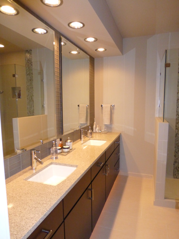 Design ideas for a mid-sized contemporary bathroom in Seattle with an undermount sink, flat-panel cabinets, medium wood cabinets, solid surface benchtops, a freestanding tub, an alcove shower, a two-piece toilet, beige tile, porcelain tile, beige walls and porcelain floors.