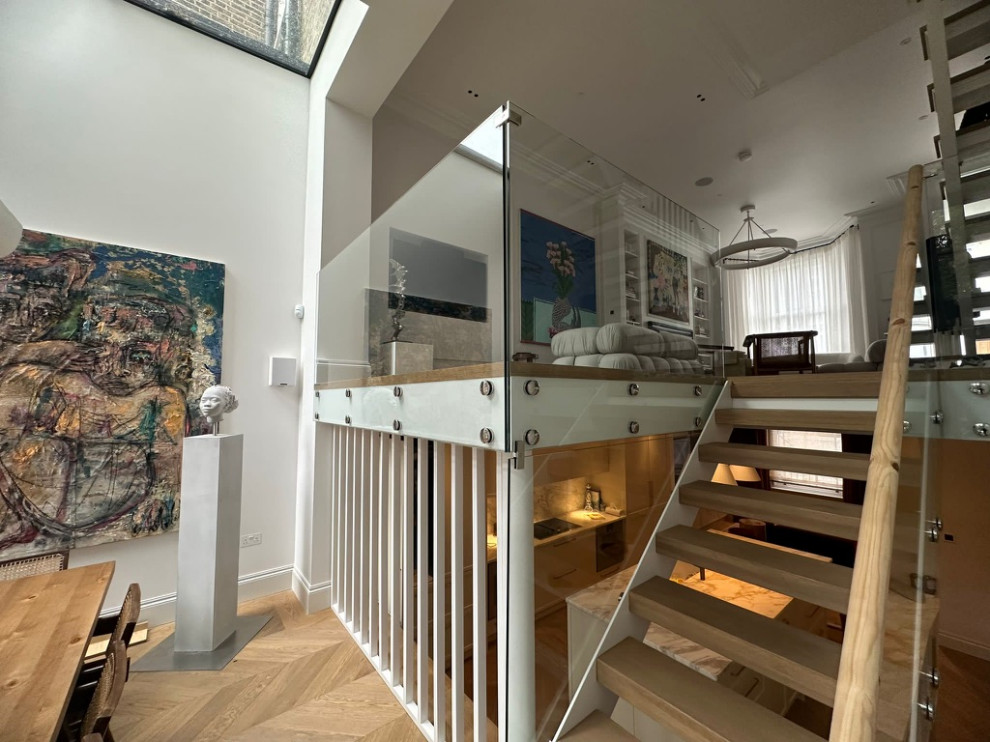 Photo of a medium sized glass floating glass railing staircase in London with brick walls.