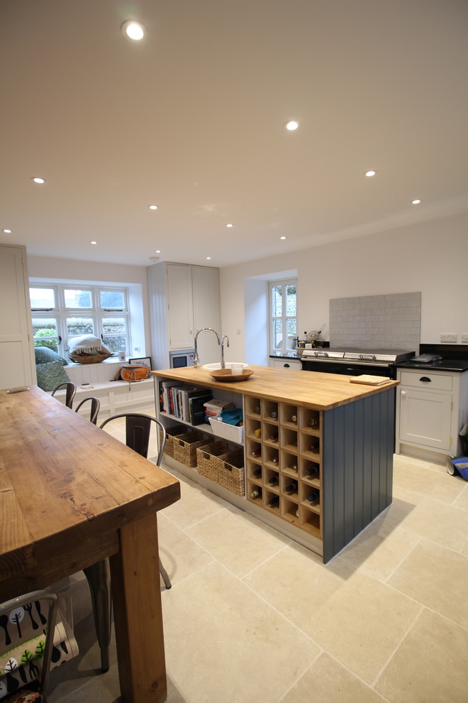 This is an example of a contemporary eat-in kitchen in Sussex with an undermount sink, shaker cabinets, grey cabinets, limestone floors and with island.