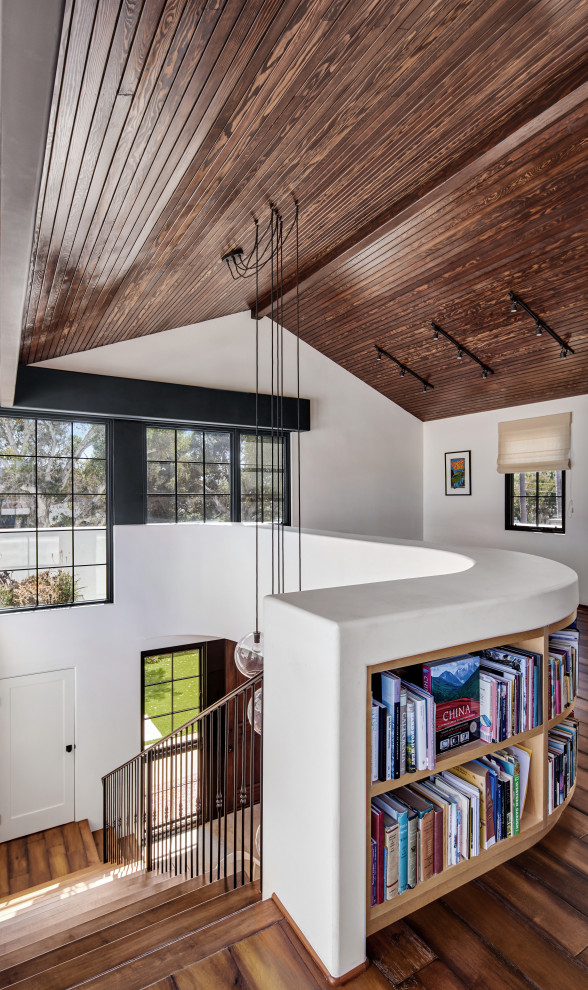 Idéer för ett mellanstort medelhavsstil allrum på loftet, med ett bibliotek, vita väggar, mellanmörkt trägolv, en fristående TV och brunt golv