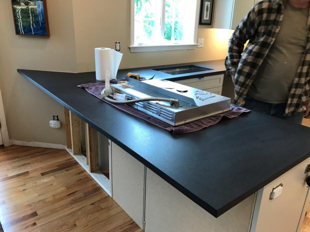 Open concept kitchen - large u-shaped medium tone wood floor and brown floor open concept kitchen idea with an undermount sink, recessed-panel cabinets, white cabinets, granite countertops, stainless steel appliances, a peninsula and black countertops