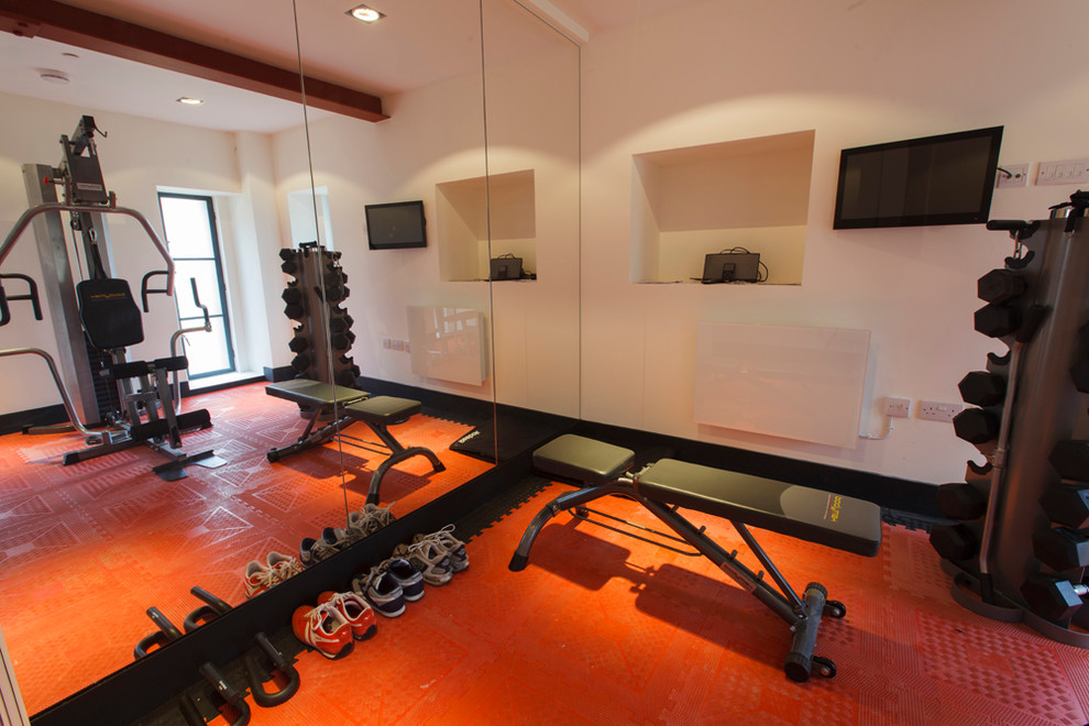Photo of an industrial home gym in London with orange floor.
