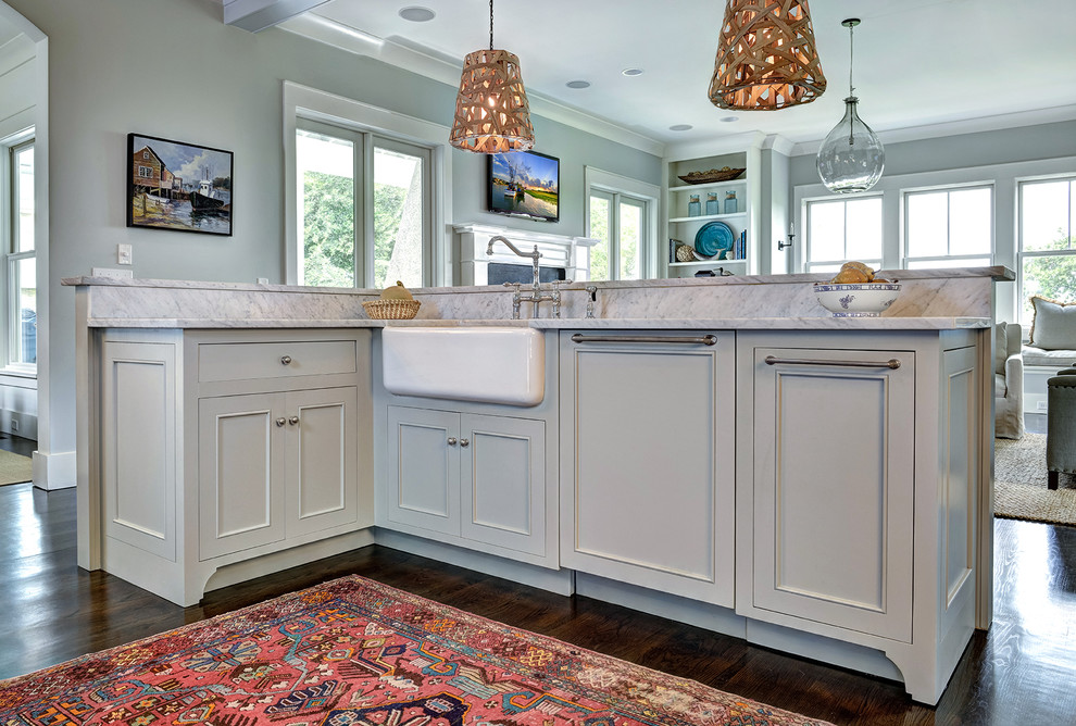 Mid-sized traditional l-shaped kitchen in Charleston with a farmhouse sink, beaded inset cabinets, grey cabinets, quartzite benchtops, white splashback, stone slab splashback, panelled appliances, dark hardwood floors, with island and brown floor.