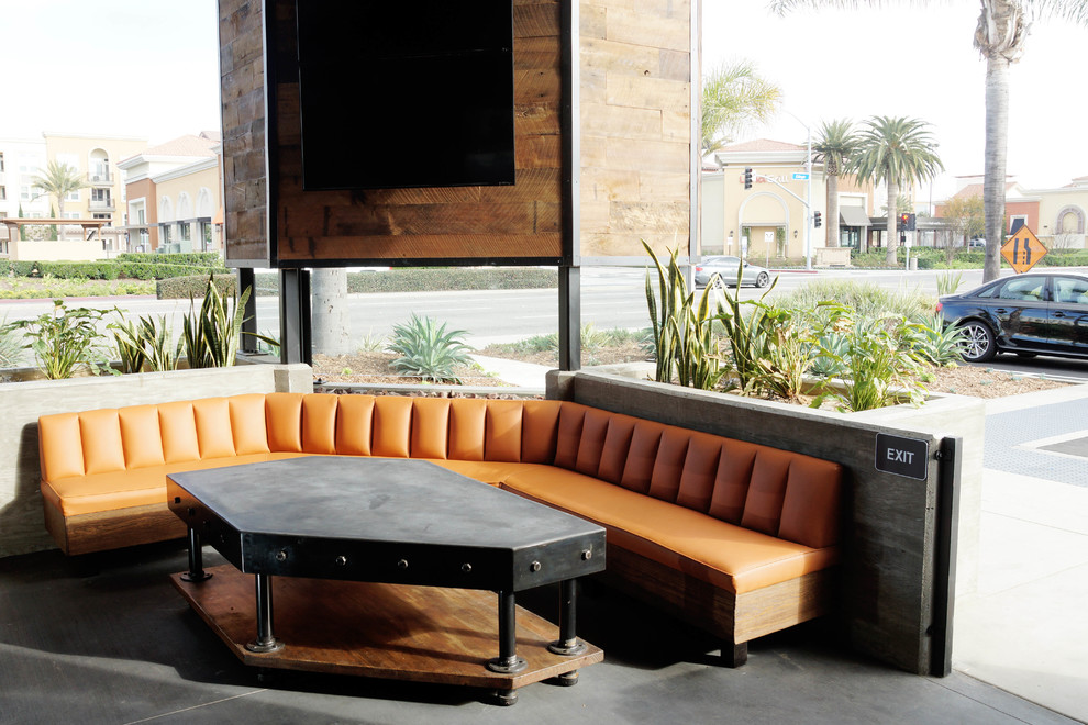 Inspiration for a large industrial open plan dining in Orange County with brown walls and concrete floors.