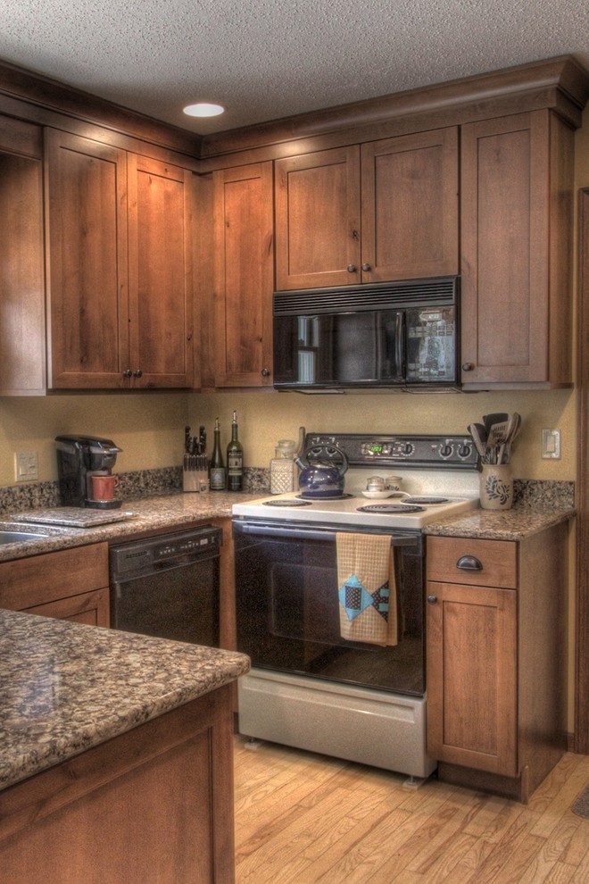 Eat-in kitchen - rustic u-shaped eat-in kitchen idea with an undermount sink, shaker cabinets, medium tone wood cabinets, quartz countertops and black appliances