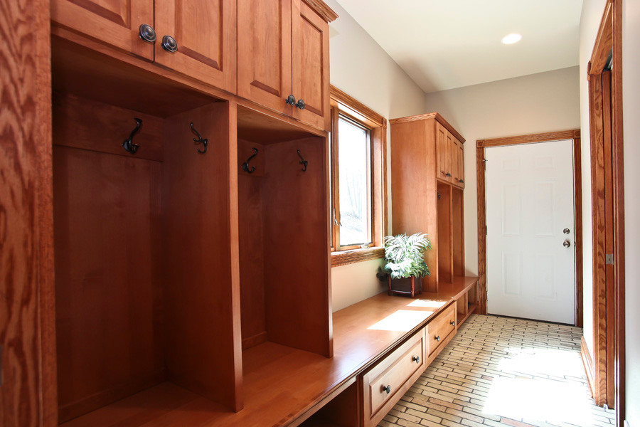 Photo of a large country mudroom in Milwaukee with grey walls, brick floors, a single front door and a white front door.